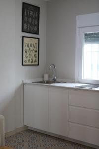 une cuisine blanche avec un évier et une fenêtre dans l'établissement Molinero, à Vejer de la Frontera