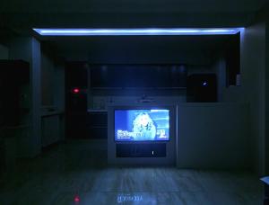 a tv in a dark room with a tv screen in a room at Heart of Skopje Luxury Apartment in Skopje +13 photos