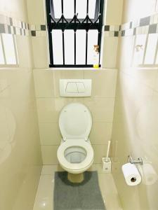 a small bathroom with a toilet with a window at Urban Park K001, Umhlanga Rocks in Durban
