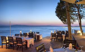 a restaurant on the beach with tables and chairs at Ephesia Holiday Beach Club in Kuşadası