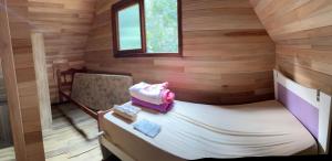 a small room with a bed and a window at Chalé do Beleza - Serra do Corvo in Braço do Norte