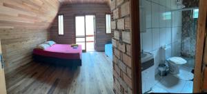 a small room with a bed and a bathroom at Chalé do Beleza - Serra do Corvo in Braço do Norte