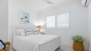 a white bedroom with a white bed and a window at Unit 3 21 Park Generous and Comfortable Beachside Abode in Sunshine Beach
