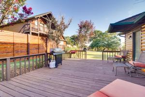 une terrasse en bois avec un grill et une maison dans l'établissement Incredible Log Home 1 Mile From Lake Tenkiller, à Vian