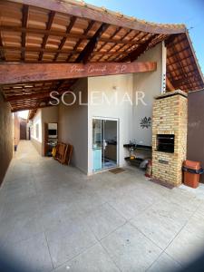 eine große Terrasse mit einem Steinkamin in einem Haus in der Unterkunft Casa de PRAIA Solemar PG 2 quarteirão do MAR in Praia Grande + 9 Fotos