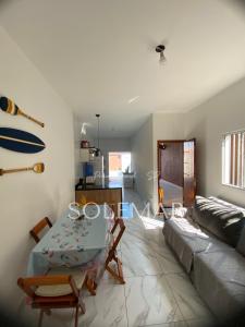 ein Wohnzimmer mit Tisch und Couch in der Unterkunft Casa de PRAIA Solemar PG 2 quarteirão do MAR in Praia Grande