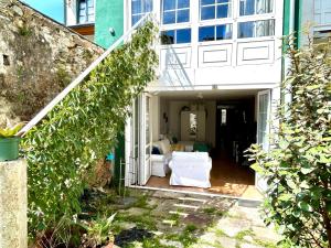 a house with a porch with a white couch at El Galeón in Ribadeo