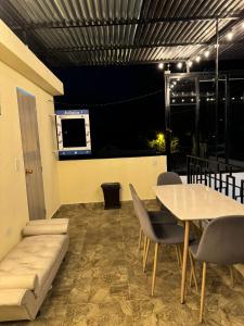 a dining room with a table and a couch at Habitaciones tipo hotel con terraza in Ibagué
