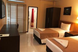 a hotel room with two beds and a desk at Lodge 61 Hotel in Bangkok