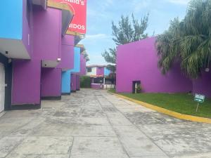 a purple building on the side of a street at Auto Hotel El Cine in El Jobo