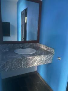 un baño con lavabo y espejo en Auto Hotel El Cine, en El Jobo 9 fotos más