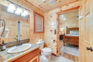 a log cabin bathroom with a toilet and a sink at Cabin with Hot Tub and Wraparound Deck in Broken Bow! in Broken Bow +28 photos