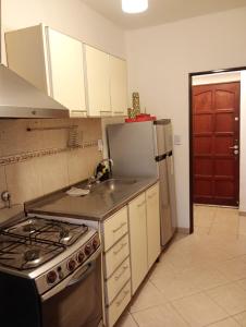 a kitchen with a stove and a sink and a refrigerator at Departamento a 150 metros de la catedral con cochera in San Fernando del Valle de Catamarca