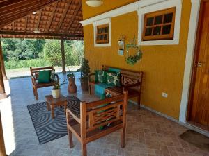 a porch with chairs and a couch on a house at Toca - Bairro Serrano in São Bento do Sapucaí