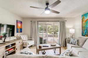 a living room with a couch and a ceiling fan at Condo with Amazing Amenities 1 Mi to Beach! in Mallory Park