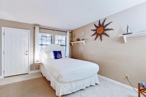 a bedroom with a white bed and a window at Mapp to Paradise in Destin