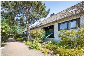 una casa con una puerta verde y algunos árboles en Cozy basement guest room in quietness, en Hannover
