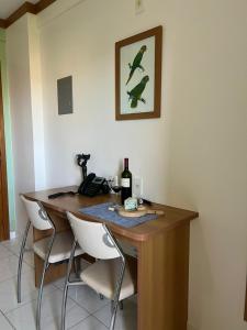 a dining room table with a bottle of wine and chairs at Apto Golden Dolphin in Caldas Novas