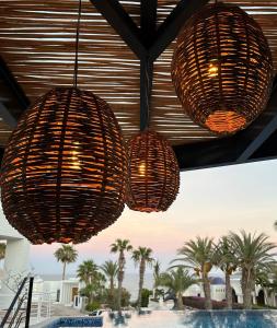 three lights hanging from the ceiling at a resort at Casa Santos Pedregal in Cabo San Lucas