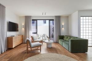 a living room with a green couch and chairs at The Clairfield Hotel in Mudgee