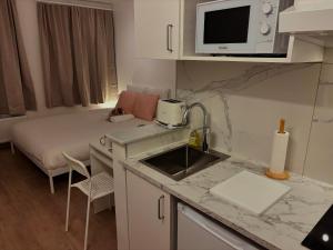 a kitchen with a bed and a sink in a room at Benny's Rooms Brussels City Centre in Brussels