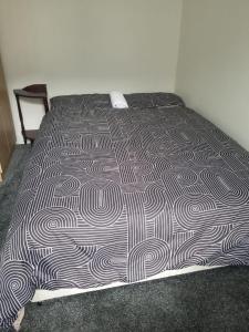 a bed with a black and white comforter at Cosy Home Stay in Etruria +11 photos