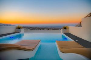 a swimming pool with a sunset in the background at Salida Del Sol Santorini in Éxo Goniá