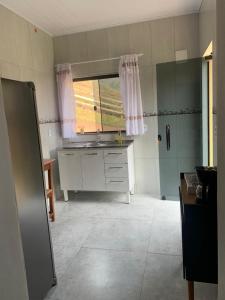 eine Küche mit einem Waschbecken und einem Fenster darin in der Unterkunft Recanto Catarina in Cunha