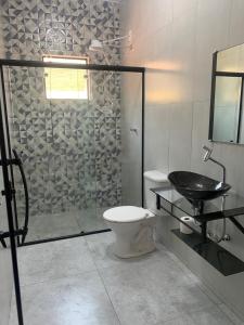 ein Badezimmer mit Dusche, Toilette und Waschbecken in der Unterkunft Recanto Catarina in Cunha