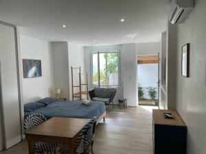 ein Schlafzimmer mit einem Bett und einem Tisch in einem Zimmer in der Unterkunft Ocean House in Noumea