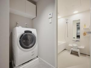 a washing machine in a bathroom with a toilet at MONday Apart Premium Asakusa in Tokyo