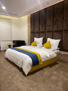 a bedroom with a large bed with yellow pillows at شقق اضواء رفا للشقق المخدومة in Al Kharj