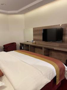 a hotel room with a bed and a flat screen tv at شقق اضواء رفا للشقق المخدومة in Al Kharj