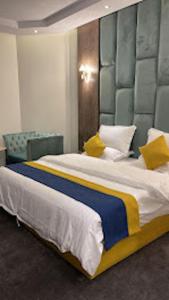 a bedroom with a large bed with yellow pillows at شقق اضواء رفا للشقق المخدومة in Al Kharj +17 photos