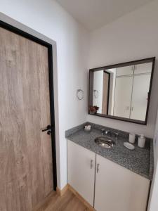 un bagno con lavandino e specchio di SJ Departamentos, Salta a Salta