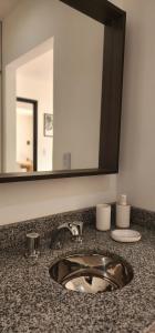 un bancone del bagno con lavandino e specchio di SJ Departamentos, Salta a Salta Altre 14 foto