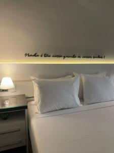 a bedroom with a bed with a sign on the wall at Apartamento Vista Jardim in São Domingos
