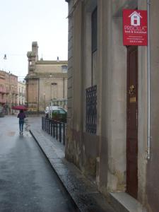 a person walking down a street with an umbrella at Bed And Breakfast Priscilla in Regalbuto