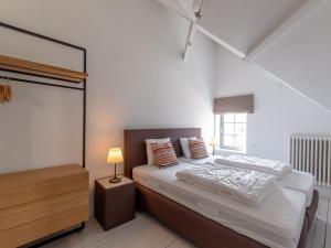 a white bedroom with a bed and a lamp at Luxury Villa in De Haan in De Haan