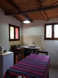 a kitchen with a table with a striped table cloth at Cabañas El Molino in Senador Pérez