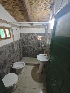 a stone bathroom with two toilets and a sink at Cabañas El Molino in Senador Pérez