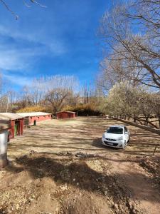 a white car parked in a parking lot at Cabañas El Molino in Senador Pérez