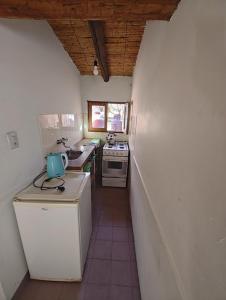 a small kitchen with a sink and a stove at Cabañas El Molino in Senador Pérez +15 photos