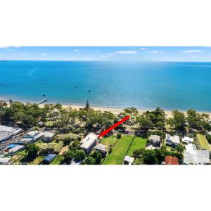 an aerial view of a beach with a red arrow at Beach villa on the esplanade in Hervey Bay +4 photos