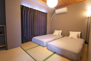 東京にあるZen Abode404 Japanese-style and modern Western-style roomsの窓のある部屋にベッドが2つある