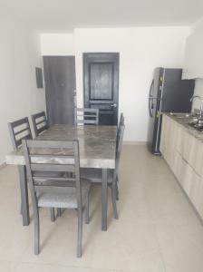eine Küche mit Tisch und Stühlen und einem Kühlschrank in der Unterkunft Departamento, cerca de playas in Mazatlán