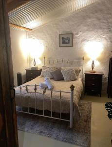 een slaapkamer met een groot bed met twee nachtkastjes bij Country Blues in Burra