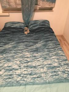 a bed with a blue blanket on top of it at Gente di mare in Novi Vinodolski
