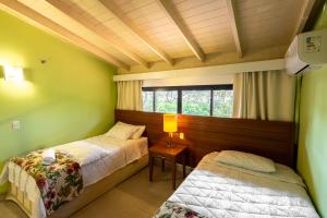 ein Schlafzimmer mit zwei Betten und einem Fenster in der Unterkunft Belíssimo Duplex no Resort Costabella em Angra dos Reis in Angra dos Reis + 41 Fotos