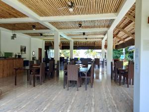 a dining room with wooden tables and chairs at Sevens Hideaway Beach Resort in Siaton